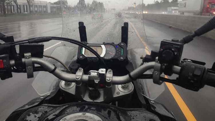 摩托车 being ridden in the rain.